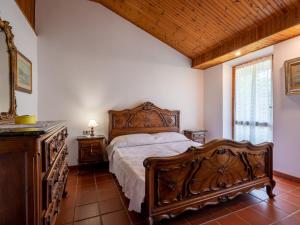 Un dormitorio con una cama de madera y un techo de madera. en Holiday Home Cascina Calore by Interhome, en Cortiglione