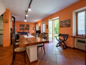 cocina con paredes de color naranja, mesa de madera y sillas en Holiday Home Cascina Calore by Interhome, en Cortiglione 17 fotos más
