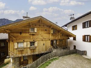 a wooden house with a fence in front of it at Apartment Delago by Interhome in Pera