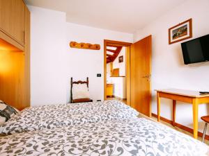 a bedroom with a bed and a desk and a television at Holiday Home Punta Emma by Interhome in Pera