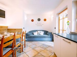 a kitchen and living room with a blue couch at Holiday Home Punta Emma by Interhome in Pera