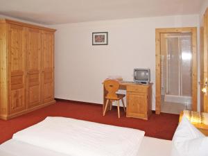 Un dormitorio con una cama y un escritorio con televisión. en Apartment Nebenhaus Schönblick - SVH111 by Interhome, en San Valentino alla Muta