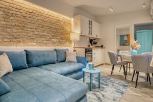 ザグレブにあるApartments Old Town Gloriaの青いソファとレンガの壁が備わるリビングルーム