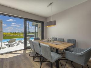 a dining room with a wooden table and chairs at Villa Stella by Interhome in Brtonigla
