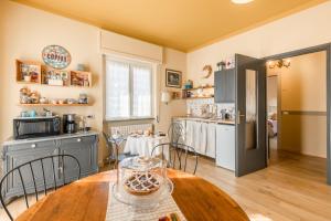 a kitchen with a table and a refrigerator at B&B Tra i Laghi in Casale Corte Cerro