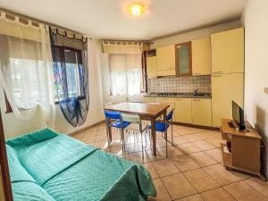 a bedroom with a bed and a table and a kitchen at Apartment Solaris-1 by Interhome in Rosolina Mare