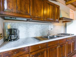 a kitchen with wooden cabinets and a sink at Holiday Home San Rocco-3 by Interhome in Greve in Chianti