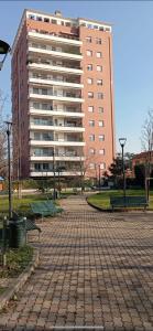 een groot gebouw voor een park met banken bij A casa di A in Milaan