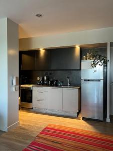 eine Küche mit weißen Schränken und einem Edelstahlkühlschrank in der Unterkunft Departamento con vista al cerro! in Yerba Buena