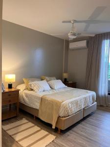 ein Schlafzimmer mit einem Bett und einer Lampe und einem Fenster in der Unterkunft Departamento con vista al cerro! in Yerba Buena