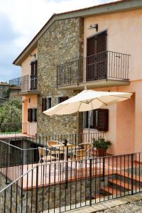 a patio with an umbrella in front of a building at Holiday Home Montechioccioli-4 by Interhome in Gaiole in Chianti