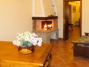 - un salon avec une cheminée et une table fleurie dans l'établissement Holiday Home Montechioccioli-4 by Interhome, à Gaiole in Chianti