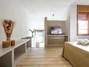 a room with a bed and a tv on a wall at Holiday Home Twoo-room Comfort by Interhome in Castiglione della Pescaia