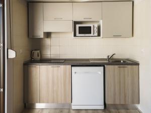 a kitchen with a sink and a microwave at Holiday Home Twoo-room Comfort by Interhome in Castiglione della Pescaia