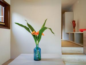 a blue vase with orange flowers sitting on a table at Holiday Home Twoo-room Comfort by Interhome in Castiglione della Pescaia +32 photos
