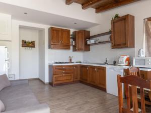 a kitchen with wooden cabinets and a counter top at Apartment Arancio by Interhome in Zafferana Etnea