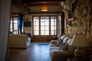 a living room with couches and a room with a door at Il figolla farmhouse in Xagħra