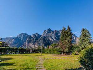 a path in a park with mountains in the background at Apartment Neumann by Interhome in Riva del Garda