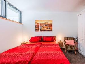 a bedroom with a red bed and a painting on the wall at Apartment Neumann by Interhome in Riva del Garda +25 photos