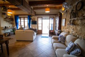 a living room with couches and a living room with a table at Il figolla farmhouse in Xagħra