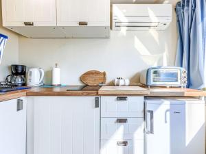 a kitchen with white cabinets and a toaster oven at Studio Nina by Interhome in Umag