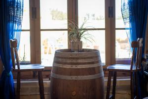 a barrel with a plant in it next to two chairs at Il figolla farmhouse in Xagħra