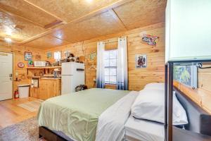 a bedroom with a bed and a kitchen with wooden walls at 8 Mi to Tellico Plains House and Cabin Near Trails! in Tellico Plains