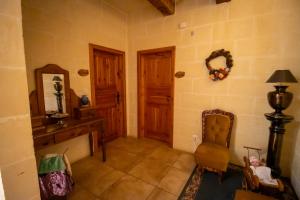 a room with two wooden doors and a chair at Il figolla farmhouse in Xagħra