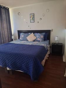 a bedroom with a bed with a blue comforter at Santiago Centro Apart in Santiago