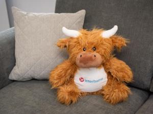 Una vaca de peluche sentada en un sofá en Apartment Harbour Nights 7D by Interhome, en Lossiemouth
