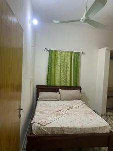 a bedroom with a bed with a green curtain at La Casa de Diane in Godomè