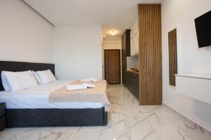a bedroom with a bed with towels on it at ARA Luxury Suites in Polykhrono +59 photos