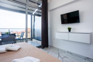 a bedroom with a tv on the wall and a bed at ARA Luxury Suites in Polykhrono