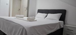 伊加洛Taksim Apartman 1的一张白色的床,上面有两条毛巾