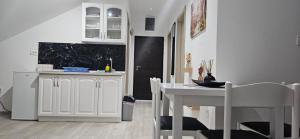 伊加洛Taksim Apartman 1的厨房里有一张白色的桌子和白色的椅子 更多9张照片
