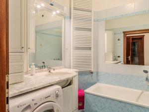 a bathroom with a sink and a tub and a mirror at Apartment Vento Alpino-3 by Interhome in Predaia