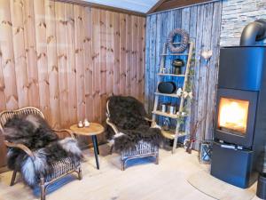 a living room with two chairs and a fireplace at Holiday Home Knodden by Interhome in Madland