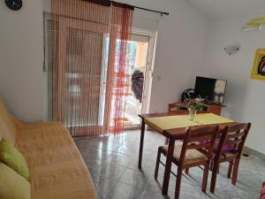 a living room with a table and a couch at Apartmani Ferri 2 in Vrbanj