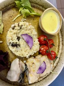 a plate of food with rice and vegetables and a sauce at Le Matagot Auberge-Restaurant in Mazeyrat-Aurouze