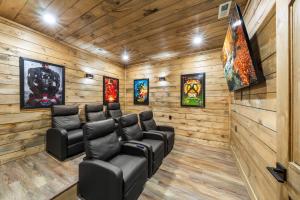 a movie room with leather chairs and paintings at Sleeps 14 - Indoor Pool, Hot Tub, Arcade Games, Movie Theatre and Pets Welcome in Pigeon Forge
