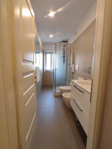 a bathroom with a toilet and a sink and a shower at Alloggi Orchidea in Negrar