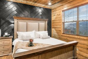 a bedroom with a bed and a wooden wall at Sleeps 14 - Indoor Pool, Hot Tub, Arcade Games, Movie Theatre and Pets Welcome in Pigeon Forge