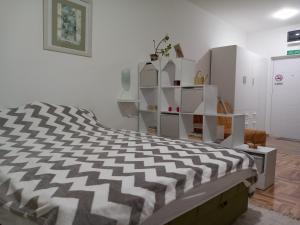 una camera da letto con un letto con una coperta bianca e nera di Studio D a Sombor