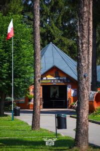 a building with a red flag in front of it at Domki Letniskowe Pod Skamieniałym Miastem in Ciężkowice