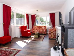 a living room with red furniture and windows at Ferienhaus Yvonne in Wendorf im Bernstein Resort in Wendorf