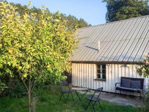 una casa con sedie e un tavolo accanto ad un albero di 7 person holiday home in Löderup a Löderup