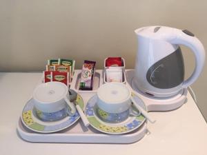 a tray with two tea cups and a coffee maker at Villa Le Favole in Sant'Egidio del Monte Albino