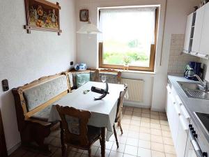 eine Küche mit Tisch und Stühlen und einem Fenster in der Unterkunft Apartment in Eifel near Nürburgring in Oberstadtfeld