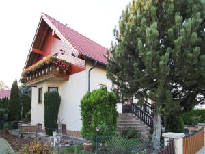 a white house with a red roof and stairs at Ferienwohnung Goehrenz bei Leipzig-Markranstaedt in Markranstädt