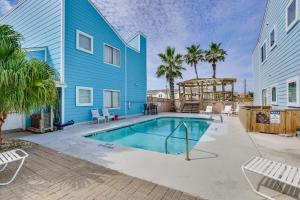a blue house with a swimming pool and palm trees at Padre Island Condo with Pool Access - Walk to Beach! in Corpus Christi